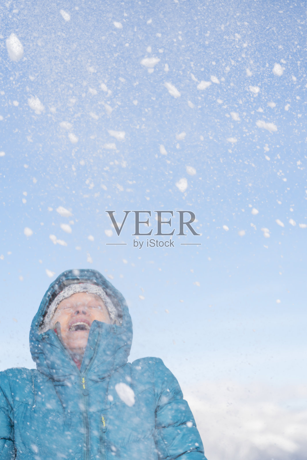 在湛蓝的天空下，成熟的女人穿着皮大衣照片摄影图片