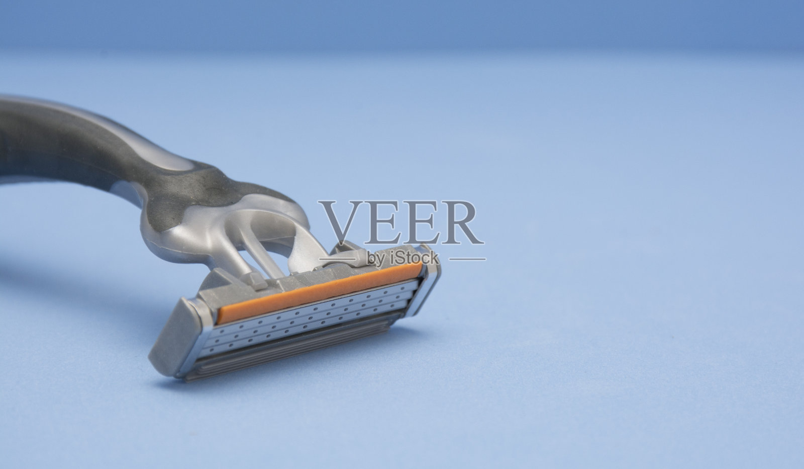 一次性剃须刀，蓝色背景。照片摄影图片