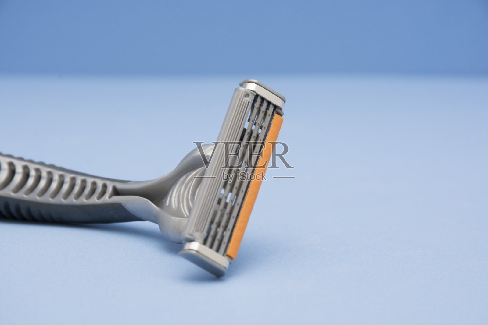 一次性剃须刀，蓝色背景。照片摄影图片