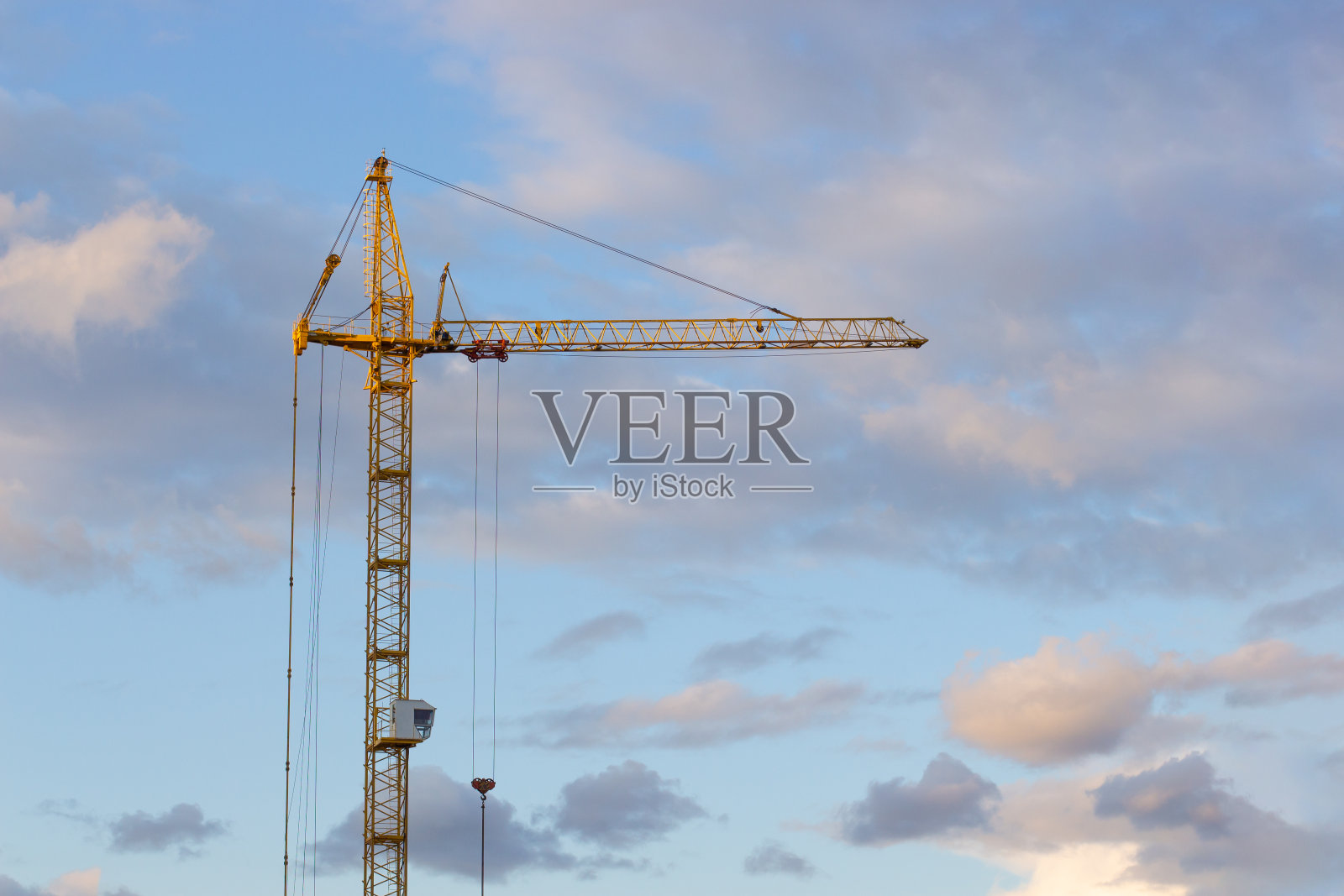 金属结构施工吊车的背景是晚霞天空与云彩照片摄影图片