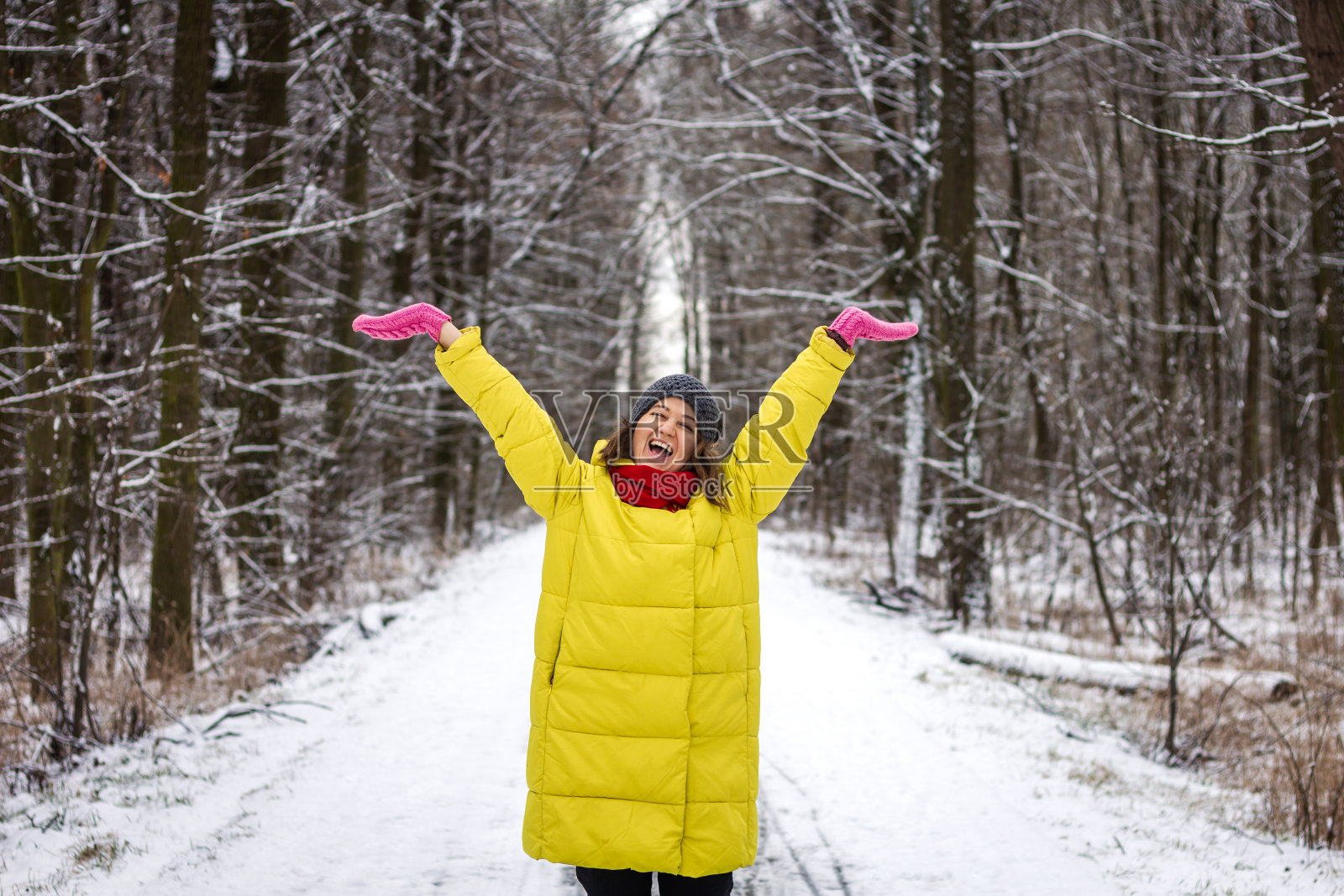 快乐的年轻女子，在冬天伸出双臂照片摄影图片