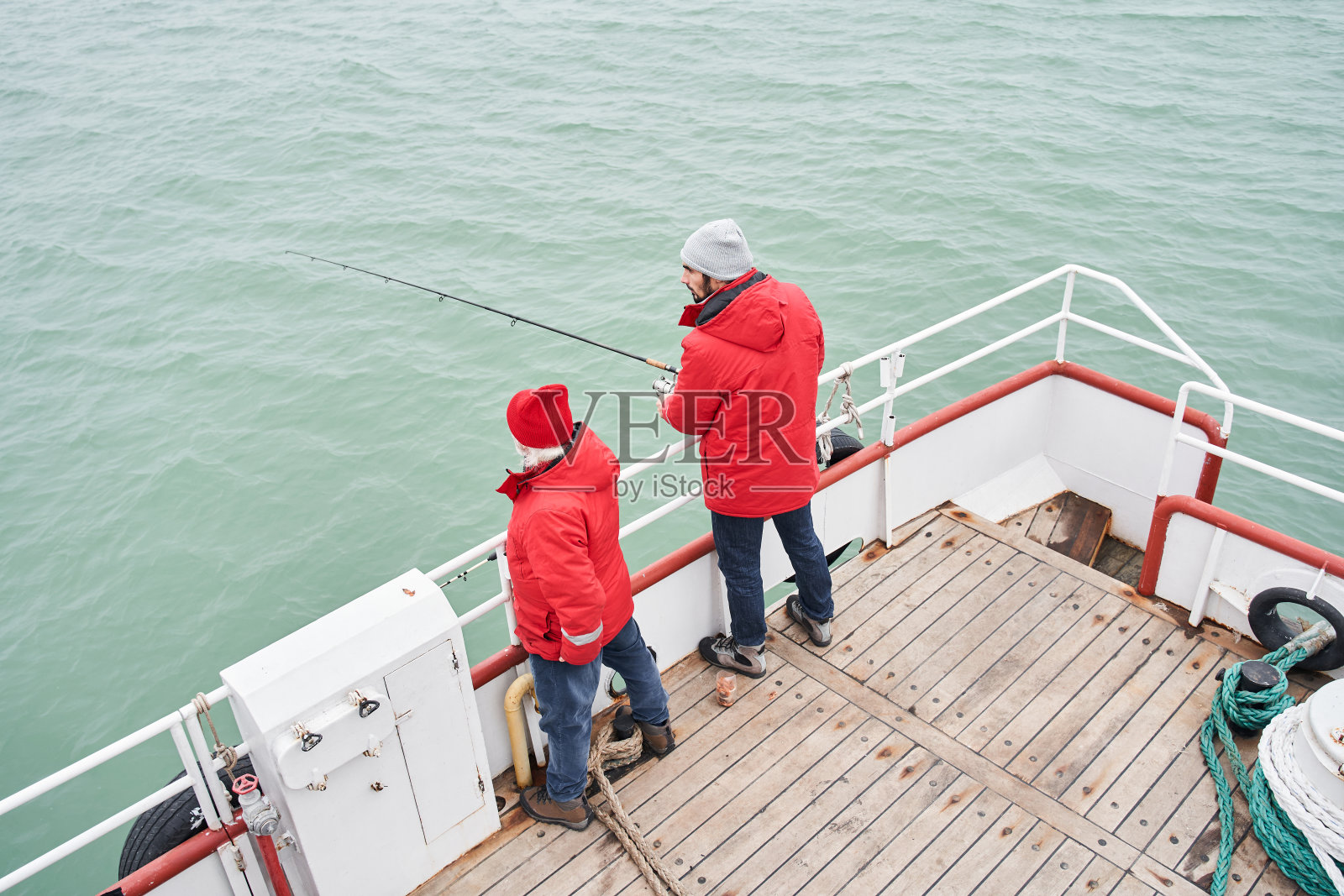 两个渔夫拿着钓竿打鱼照片摄影图片