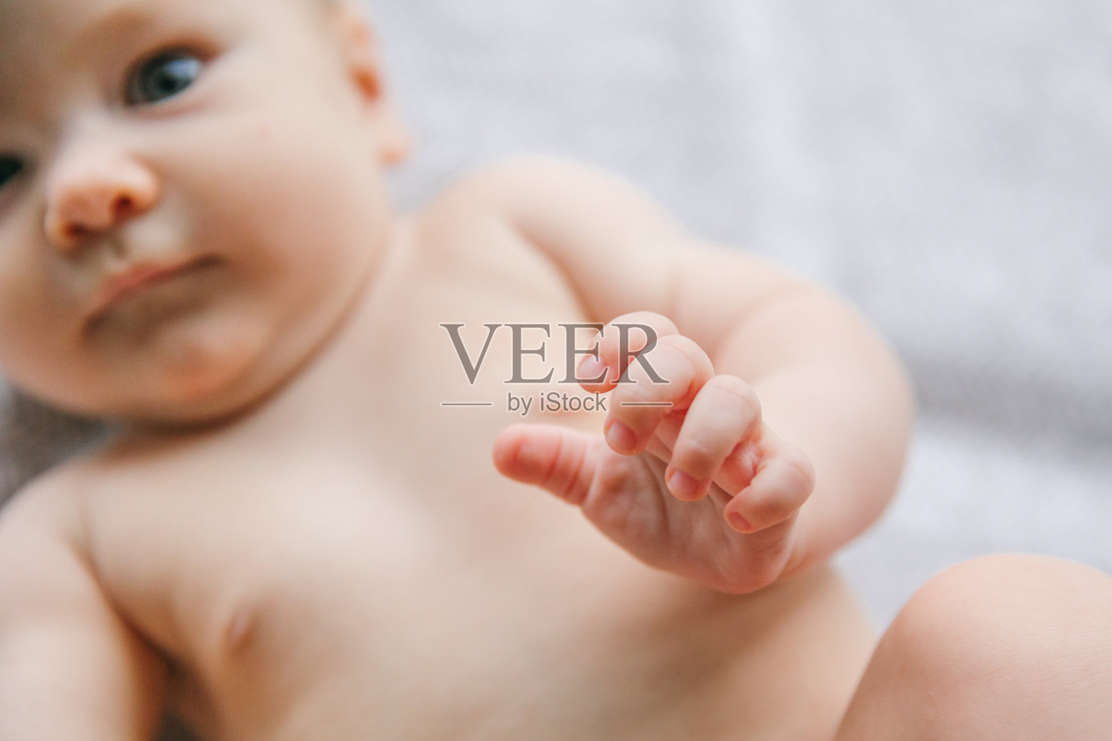 三个月大的新生儿微笑和说谎。心理运动发育和婴儿护理照片摄影图片