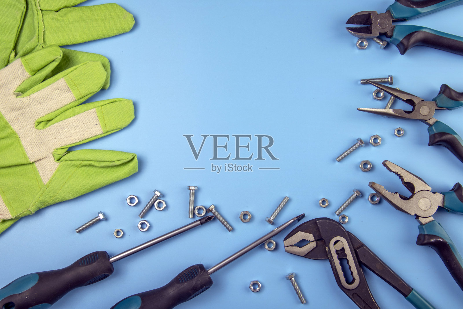 一套修理工具-螺丝刀，钳子，配件在浅蓝色的背景上，中间有文字的地方。从以上观点。照片摄影图片