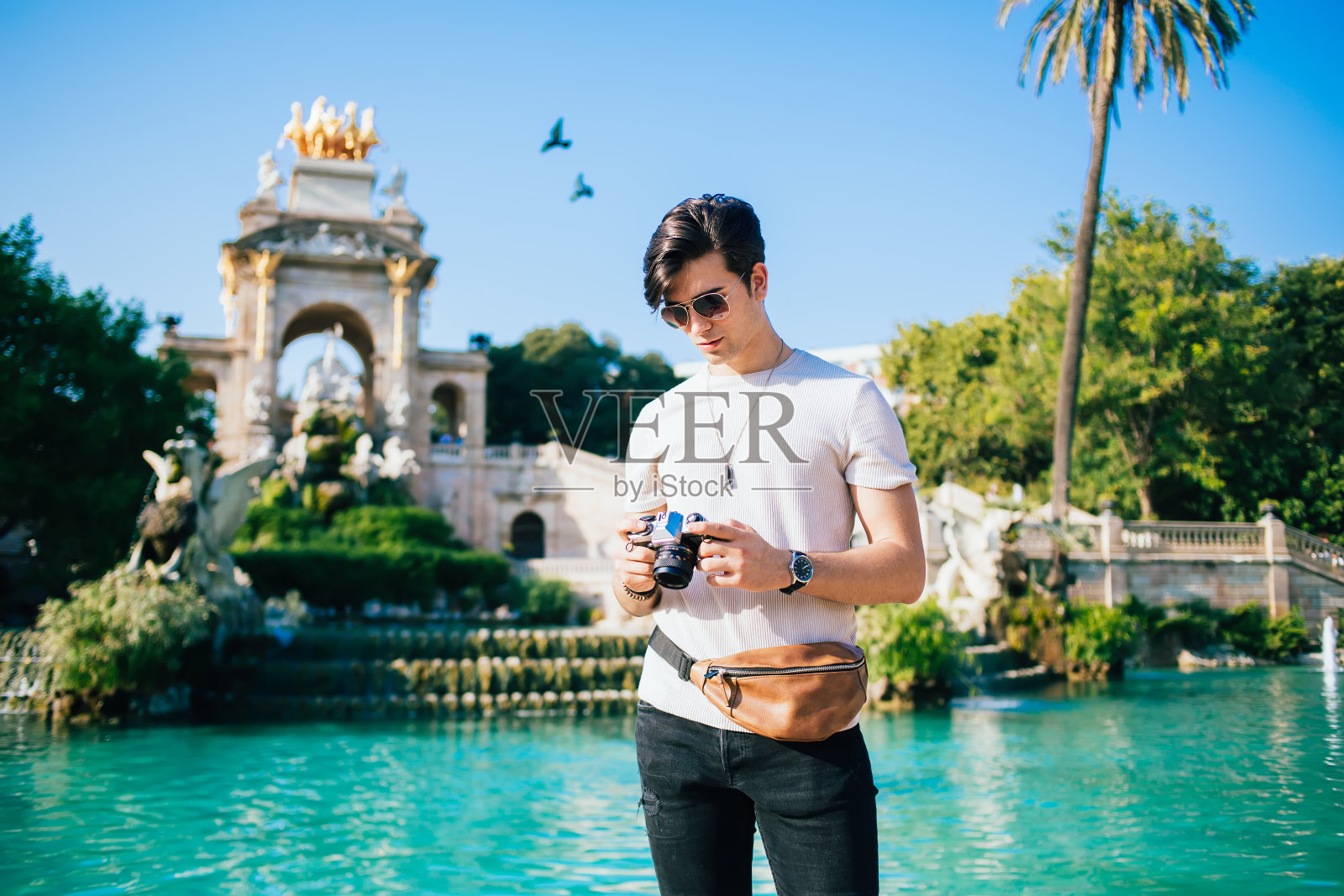 西班牙旅行男子在公园散步时带着相机照片摄影图片
