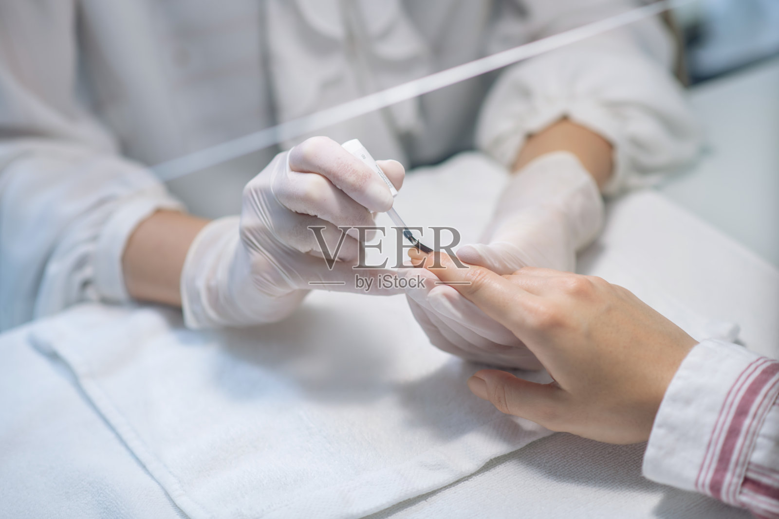 近距离图片的指甲艺术家的手应用指甲基地照片摄影图片