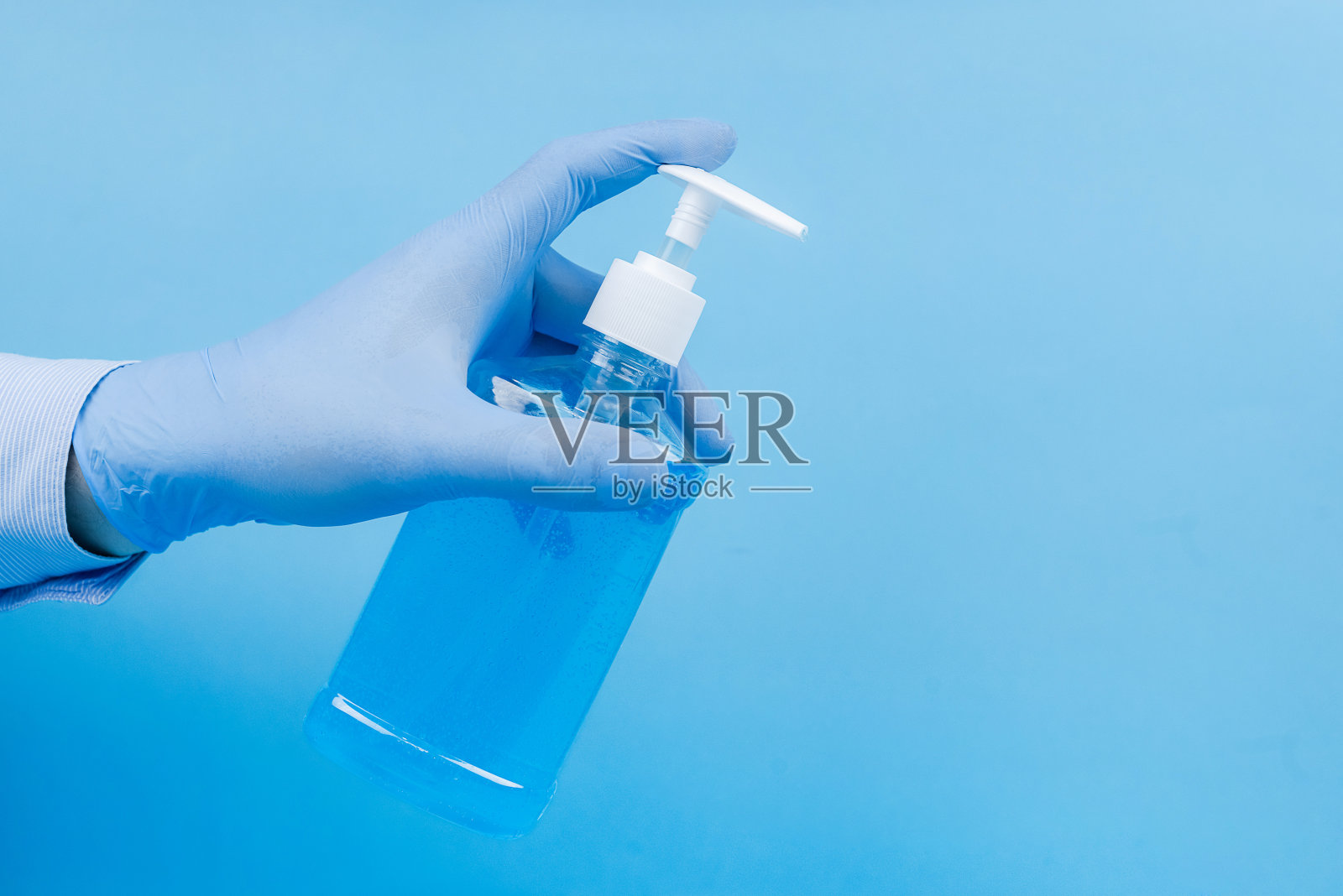 医生的手在医疗手套在心脏形状的蓝色背景与副本空间照片摄影图片