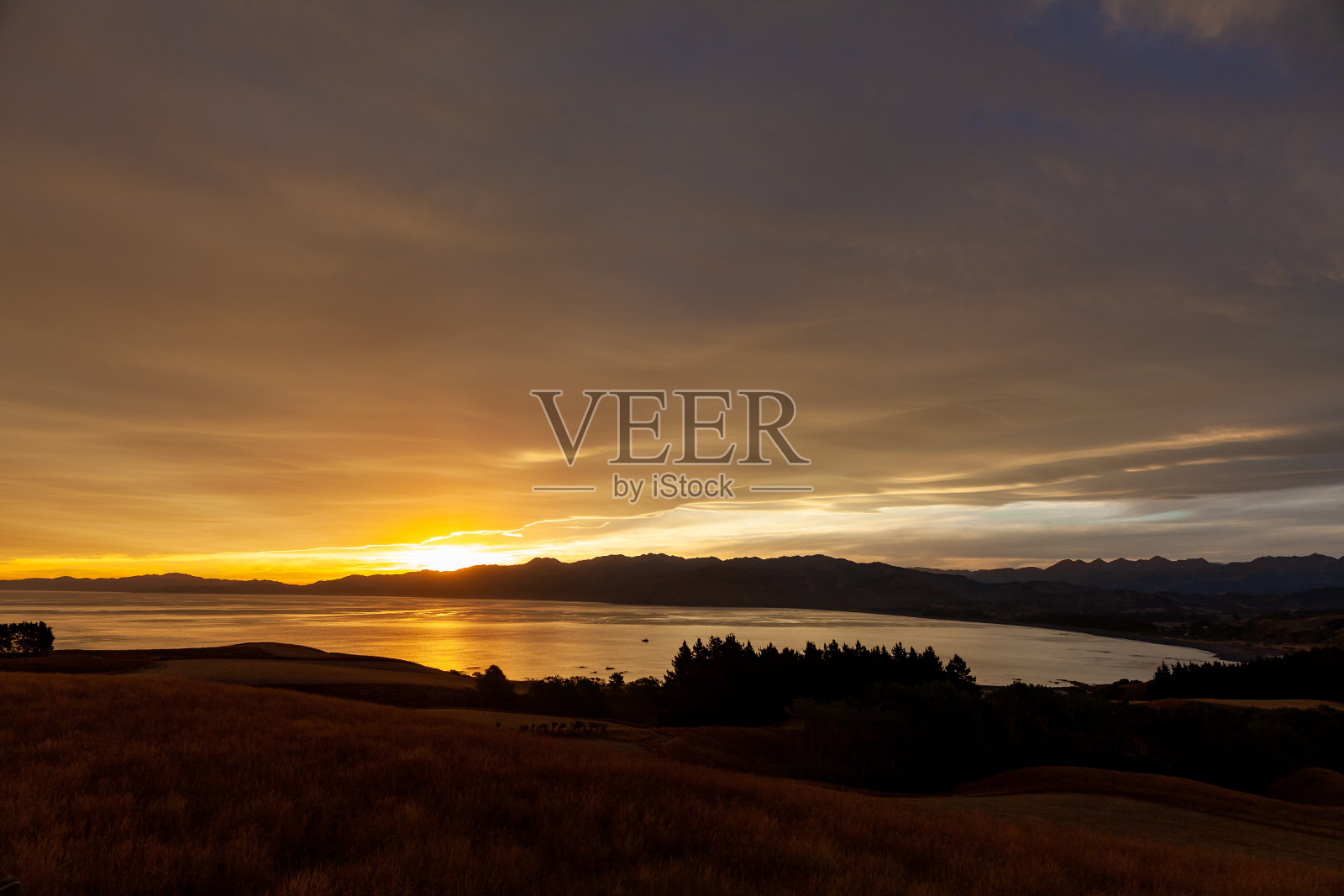 色彩斑斓的海滩日出与深蓝色的天空和阳光。照片摄影图片