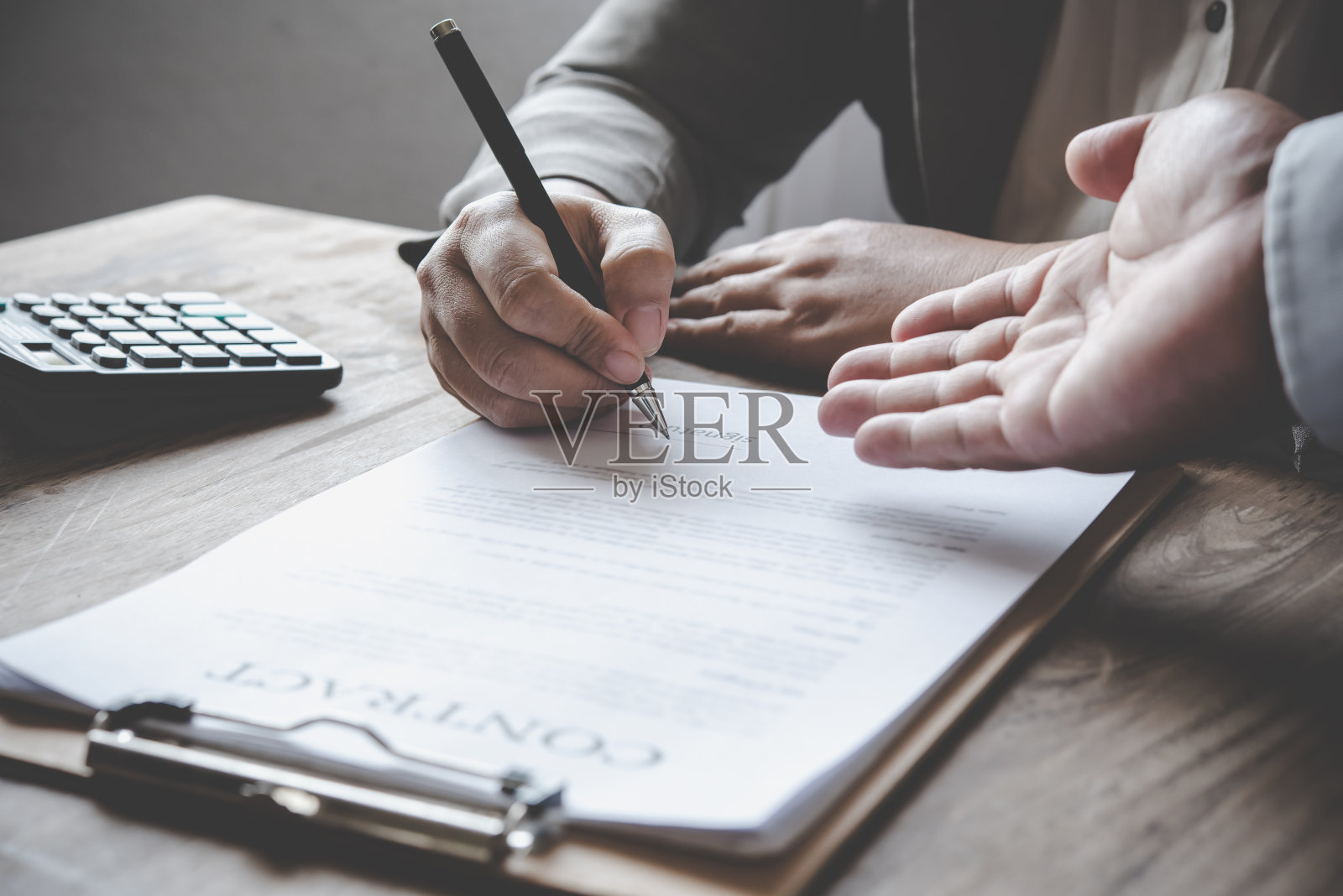 商人正在谈判，建议，并解释合同的事项，同意签署合同。照片摄影图片