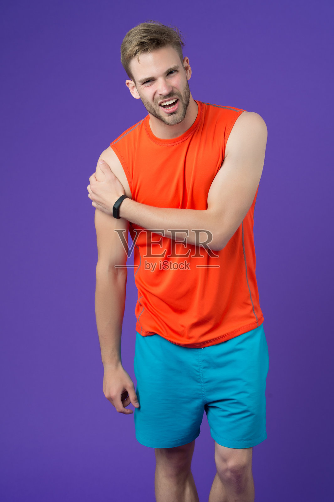 再次感受那种痛苦。运动员肩关节受伤。男人遭受着旧的创伤，慢性的疼痛，紫罗兰的背景。运动员冒险锻炼身体创伤。小伙子痛脸碰伤胳膊照片摄影图片