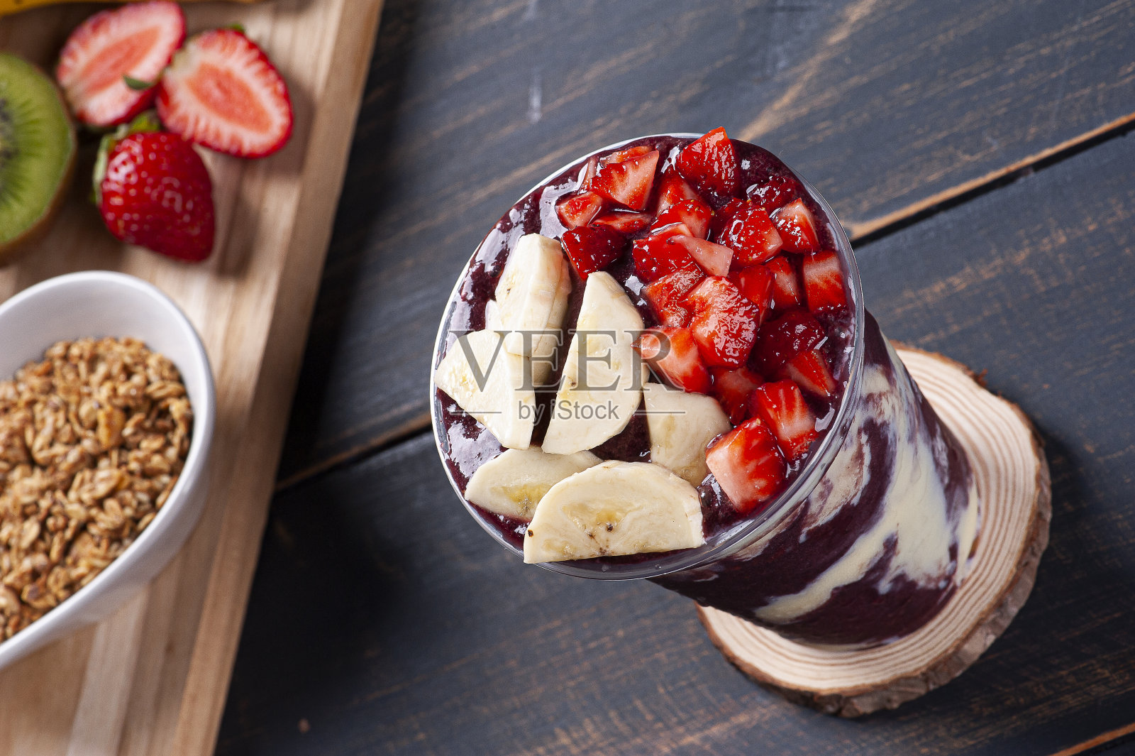 巴西冰冻açaí在一个塑料杯与炼乳和热带水果。来自亚马逊的水果。照片摄影图片