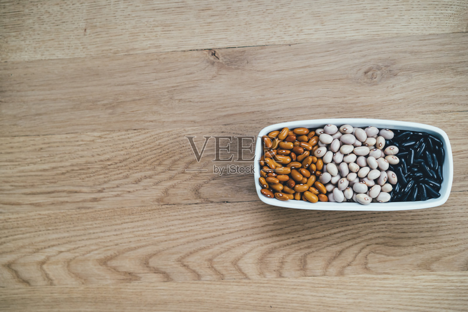 各种各样的豆子在木制背景上。副本的空间。照片摄影图片