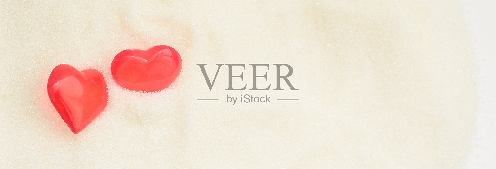 两个爱情情人节的心在甜蜜的糖的背景。照片摄影图片