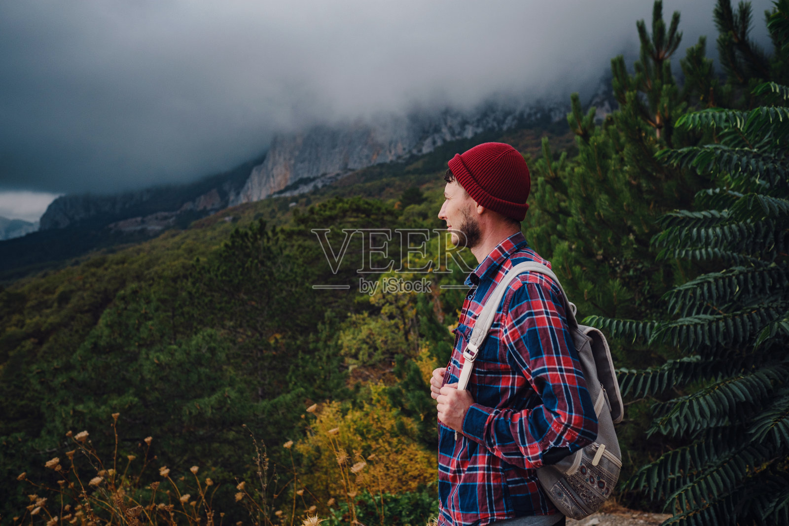 男子背包旅行在山里徒步旅行。照片摄影图片