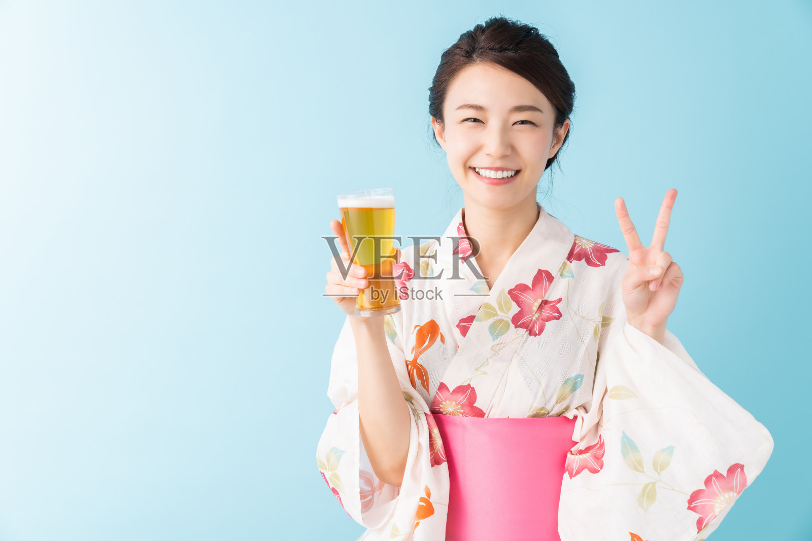 亚洲妇女穿着传统的日本休闲夏季和服“浴衣”，喝啤酒照片摄影图片