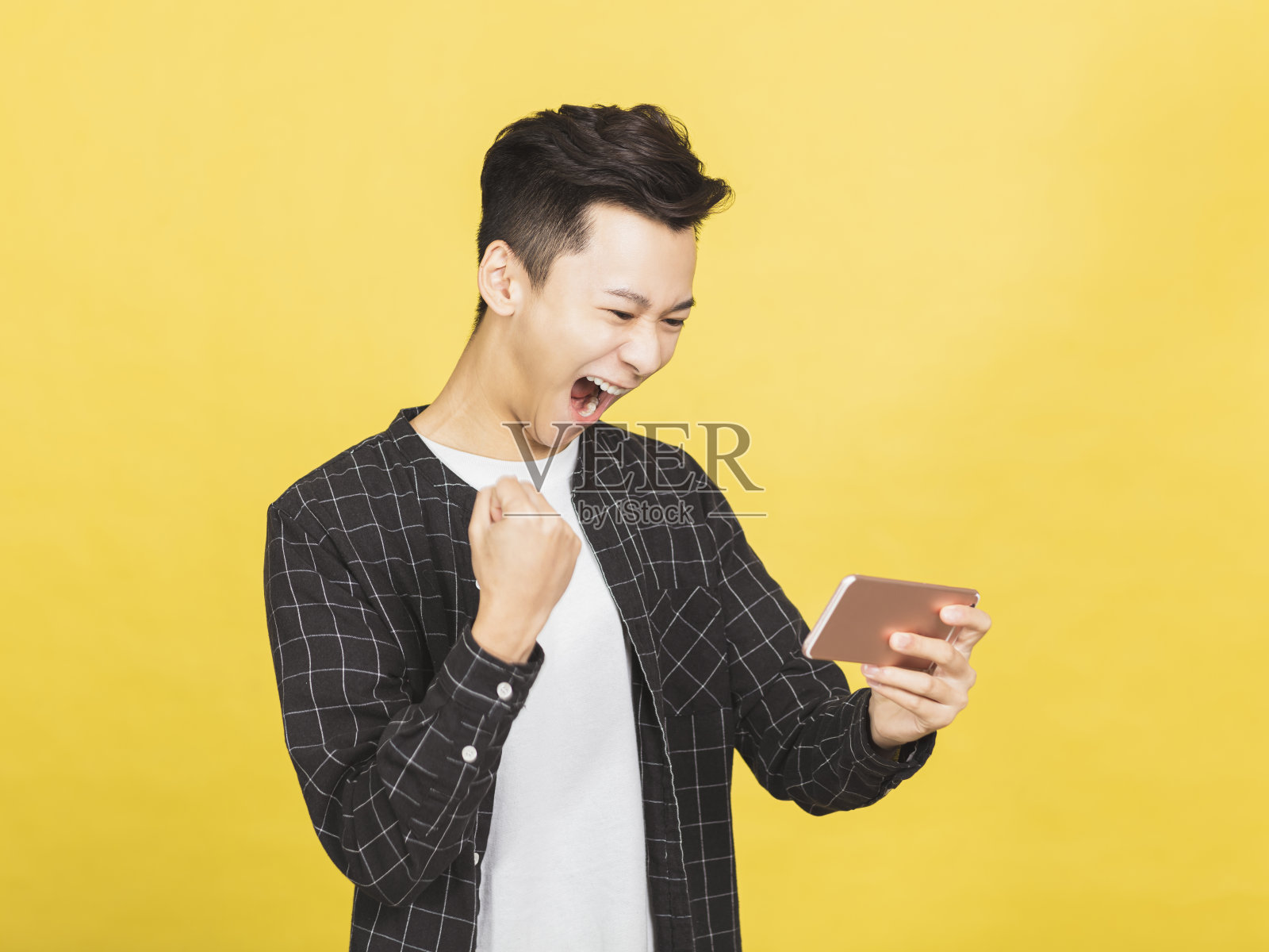 快乐的年轻人在看智能手机上的信息庆祝胜利照片摄影图片