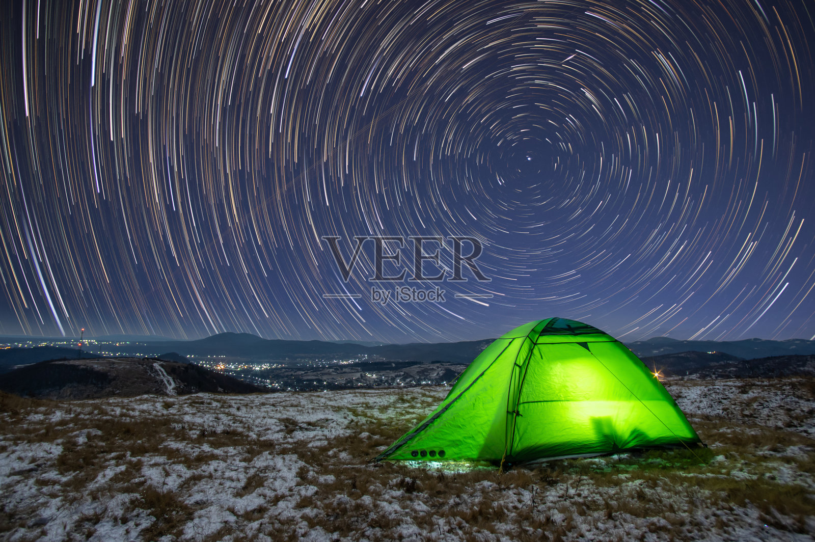 在冬天的夜晚，在山顶的一个帐篷上进行星际之旅照片摄影图片