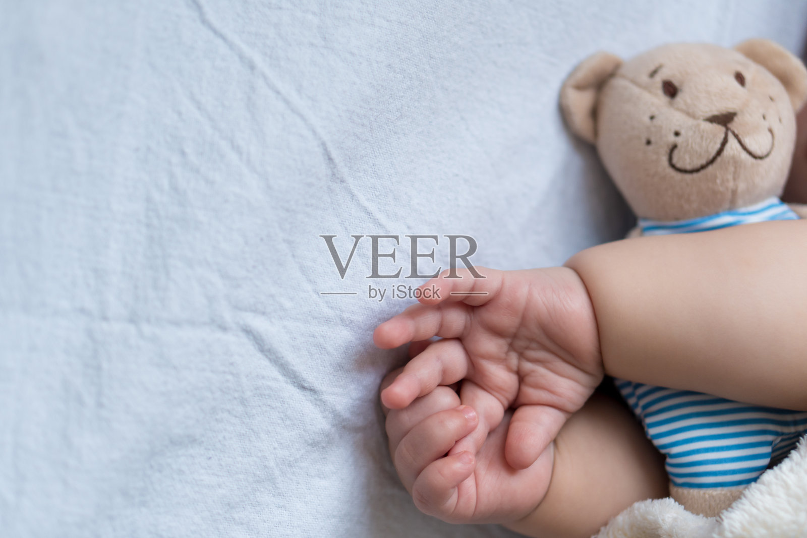 童年，关怀，母亲，健康的概念-靠近小和平平静的婴儿学步的婴儿女孩睡觉休息，打个盹躺着拥抱泰迪熊玩具在柔软温暖的毯子上，闭上眼睛在大床上照片摄影图片