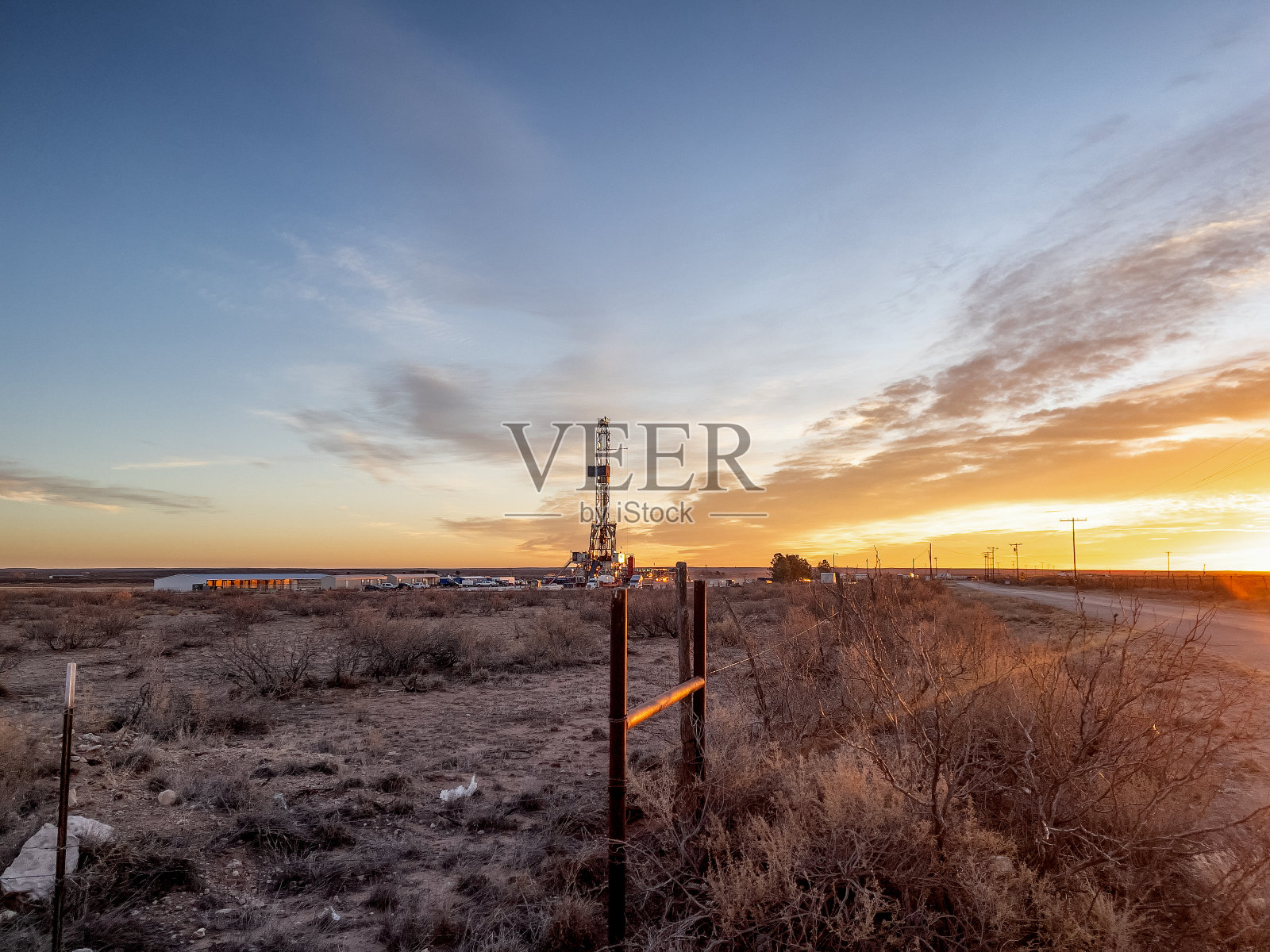 新墨西哥州，太阳落山时的石油或天然气钻井平台照片摄影图片
