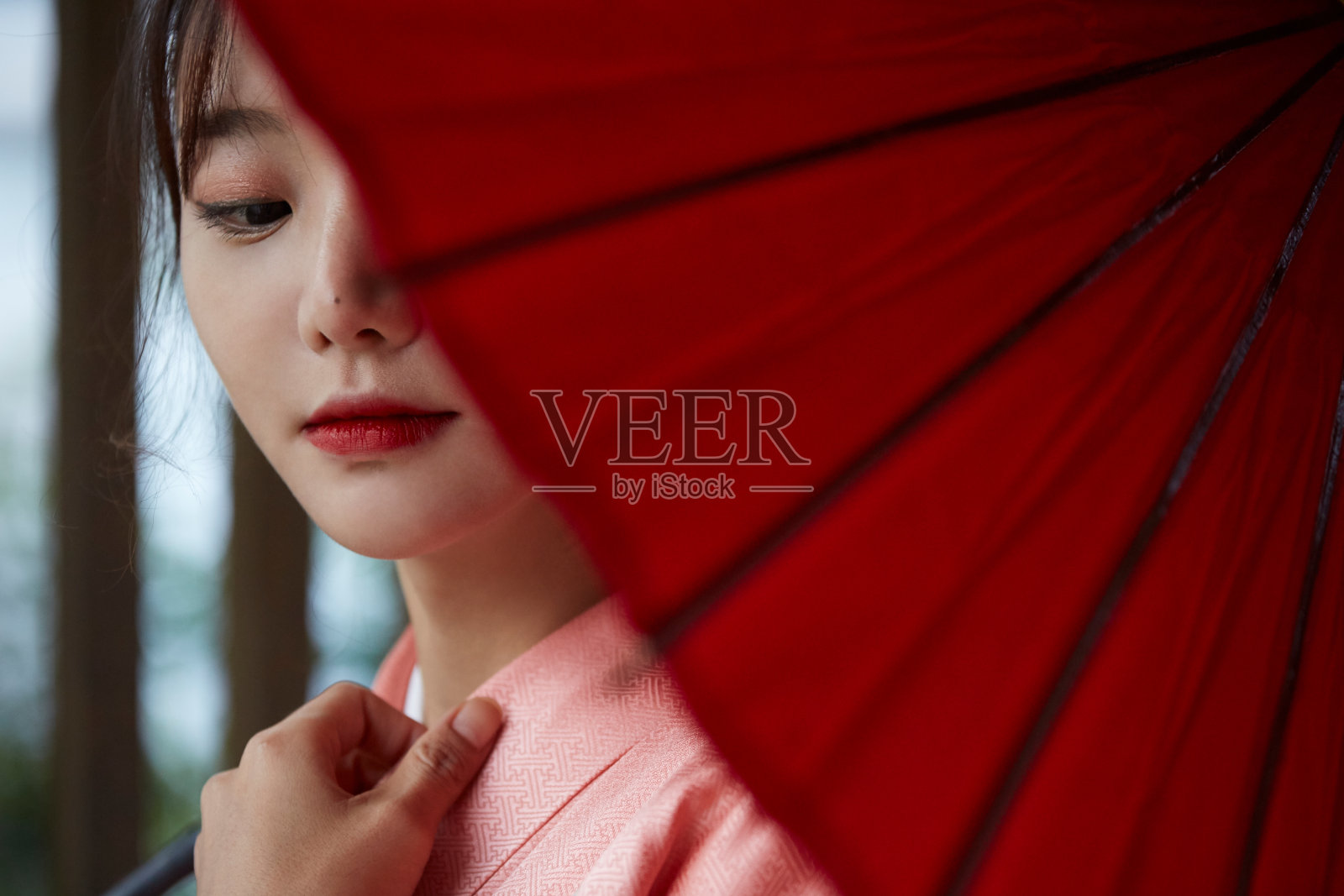 穿着和服，带着红色日本伞的年轻女子照片摄影图片