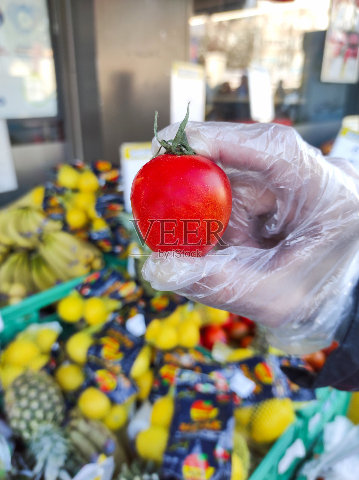 去杂货店买戴手套的西红柿照片摄影图片