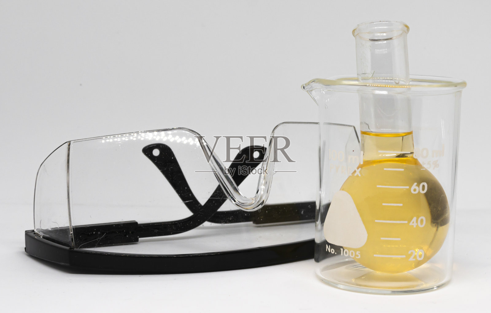 科学安全眼镜旁边的烧杯黄色液体照片摄影图片