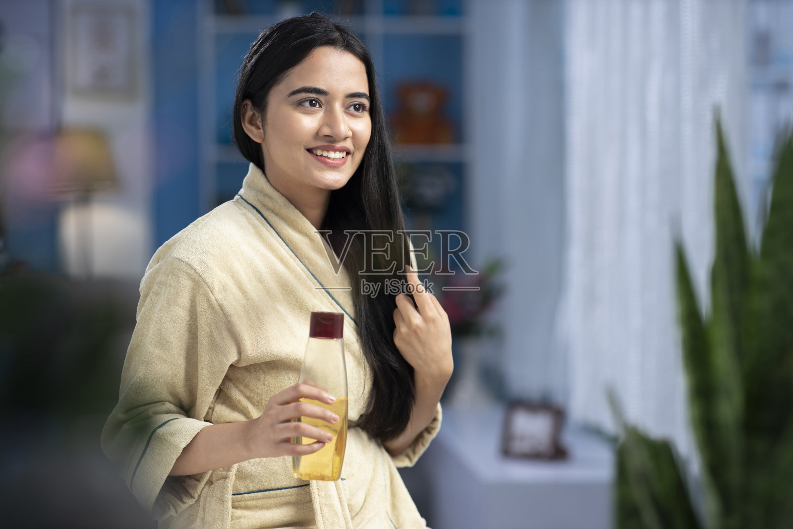 年轻女性在头发上涂油，护发库存照片照片摄影图片