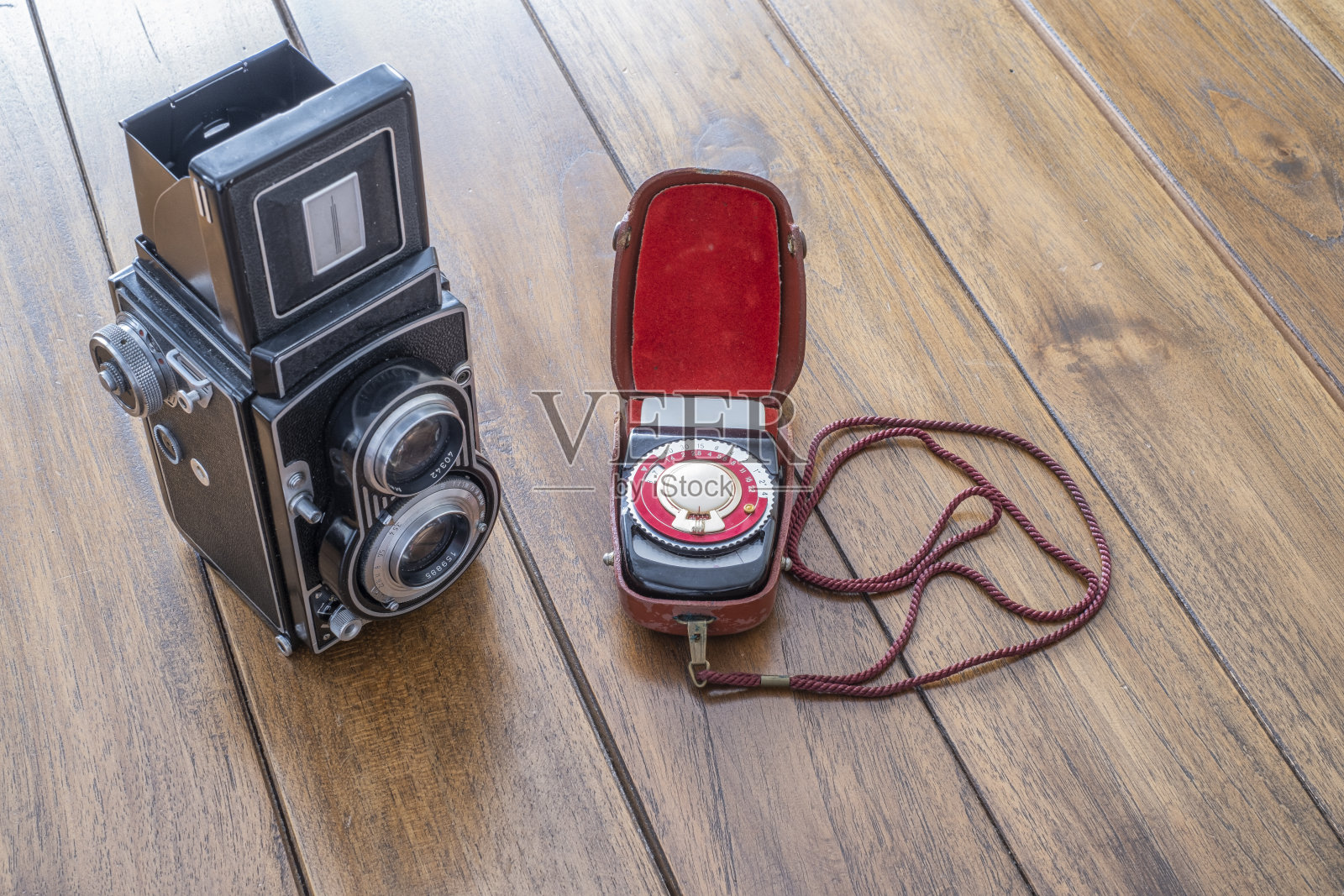 一个古董双镜头反射光相机的特写放在木桌上，和一个古董手持式光度计照片摄影图片