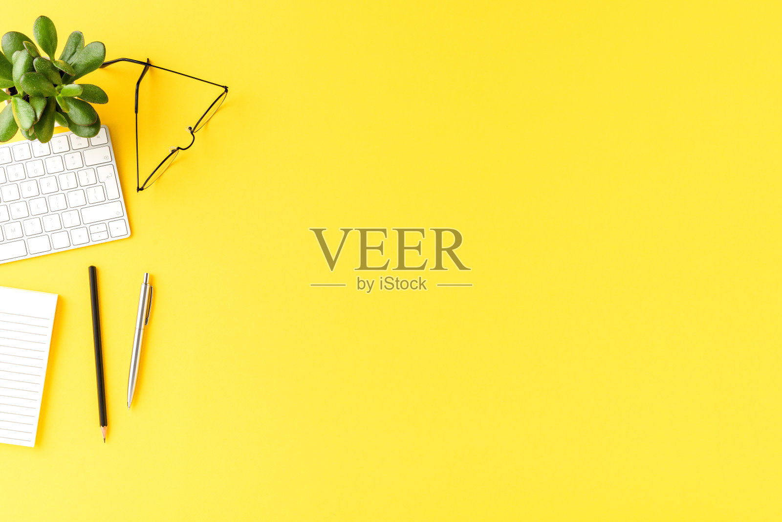 电脑键盘，笔记本，眼镜和笔，优雅的办公环境。办公室桌面的概念照片摄影图片