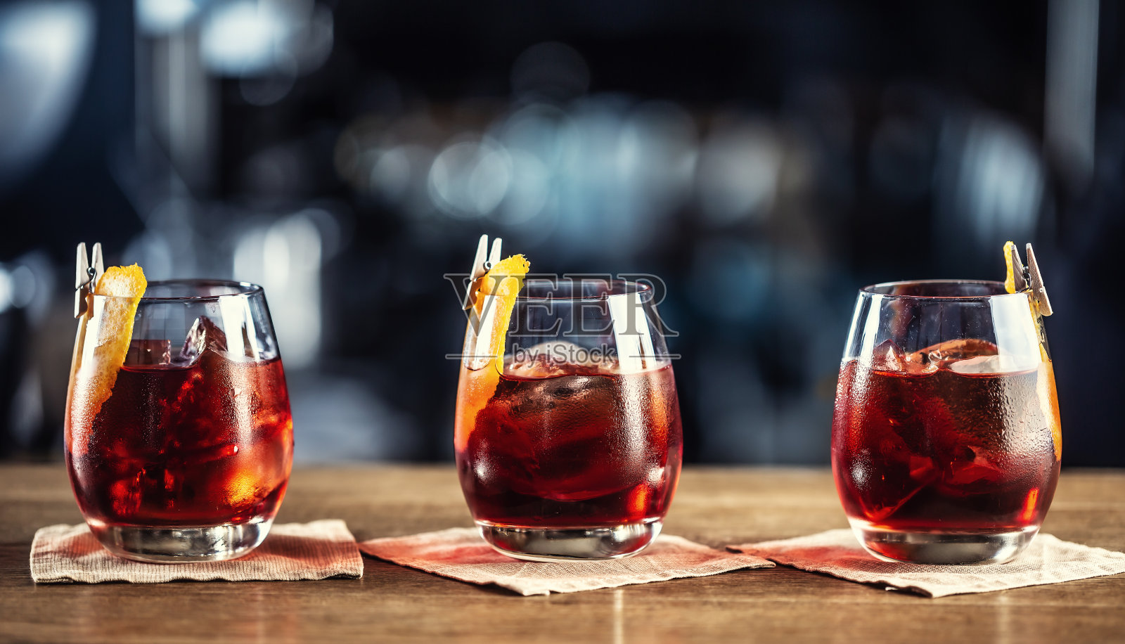 内格罗尼经典鸡尾酒和杜松子酒短饮与甜苦艾酒，红色苦利口酒和干橙装饰。照片摄影图片