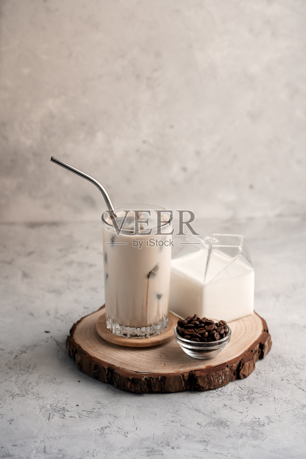 在灰色的石头背景上，用冰块冰冻的咖啡制成的奶昔的静物。照片摄影图片