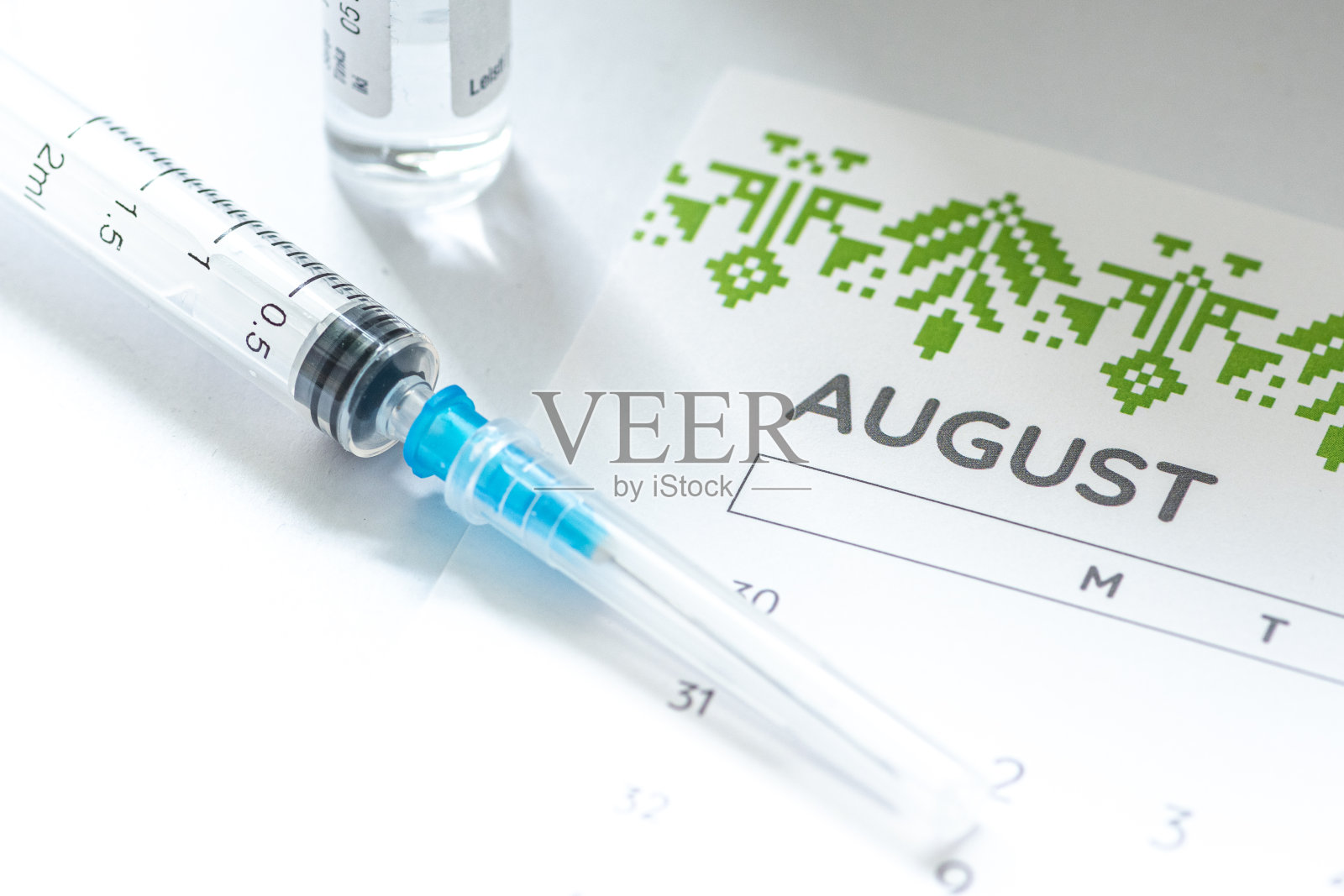 注射器，小瓶和日历有8月份照片摄影图片