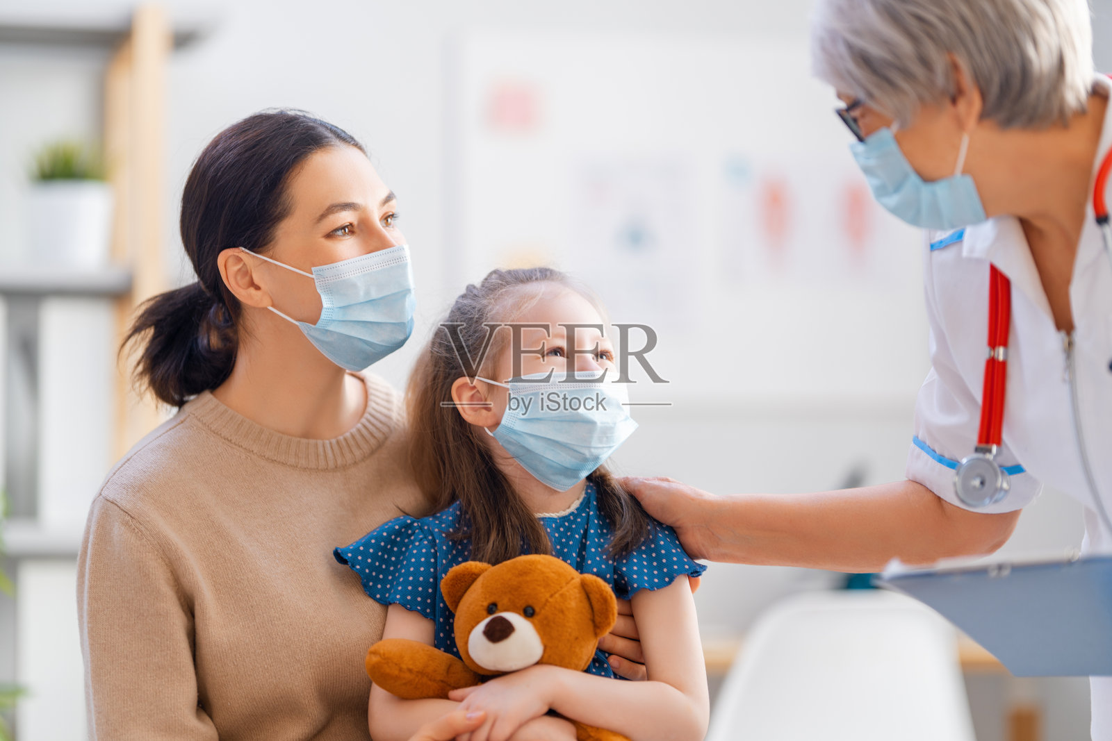 医生，孩子和母亲都戴着口罩照片摄影图片