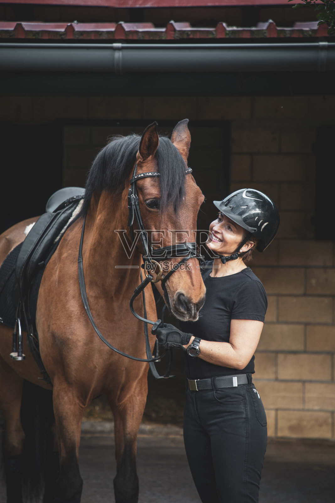 女牛仔和她的马在马厩里照片摄影图片