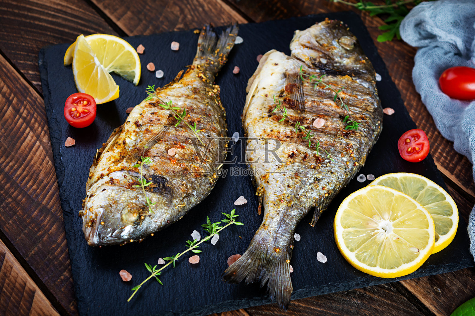 木制背景上的烤多拉多鱼：香料和草药烤海鱼照片摄影图片