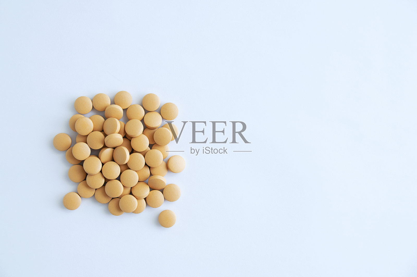 白色背景上的棕色圆形食物补充丸。照片摄影图片