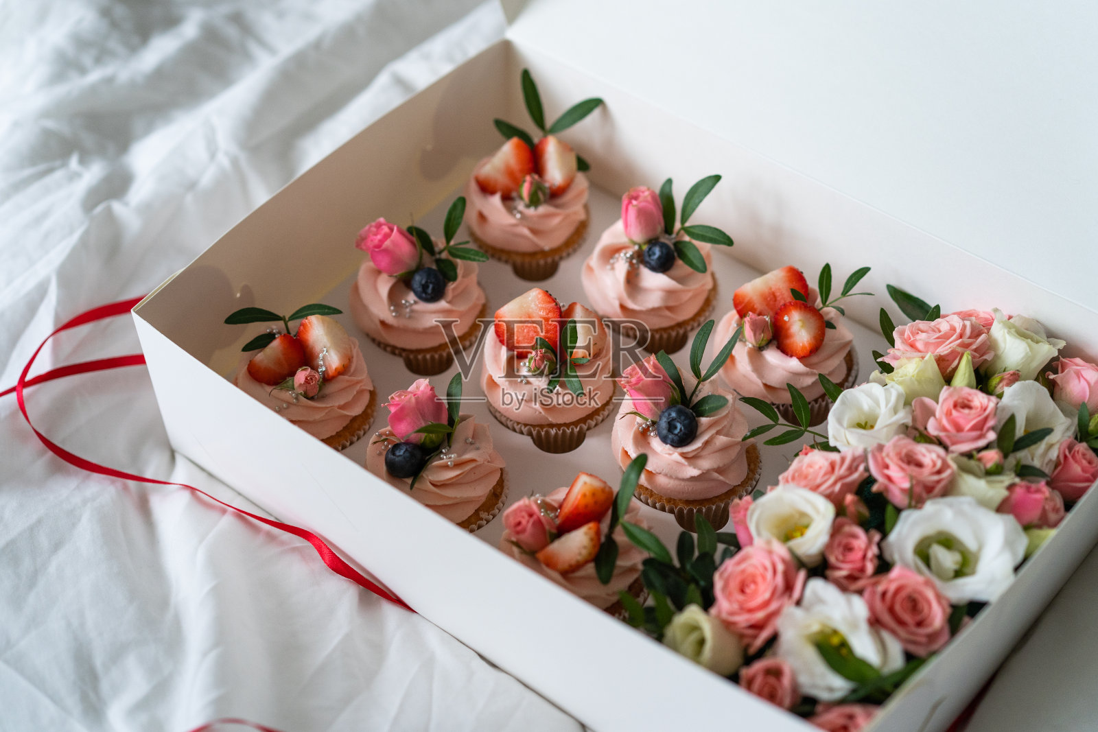 粉色纸杯蛋糕的节日盒。生日聚会。照片摄影图片