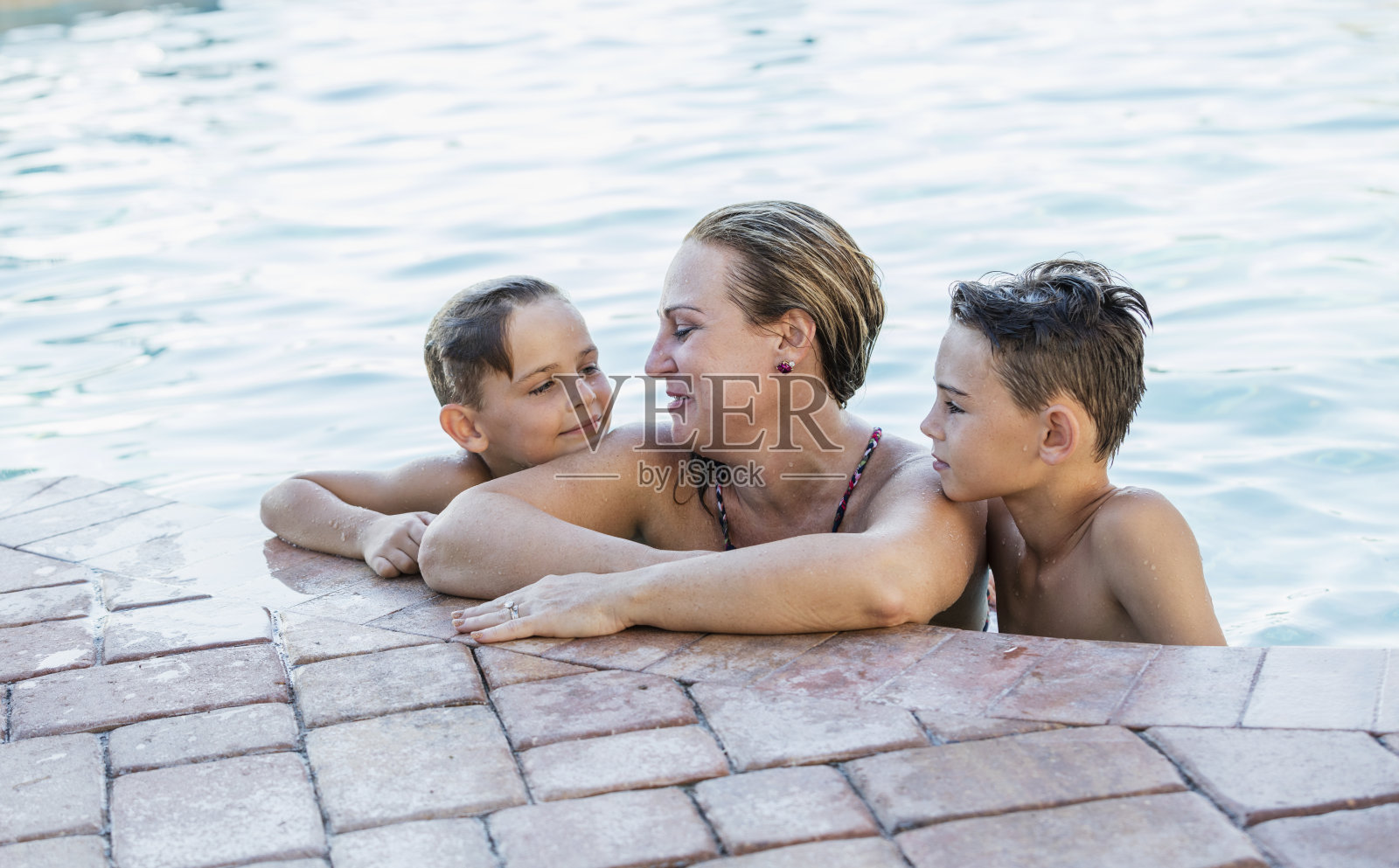 两个男孩和母亲在游泳池里照片摄影图片
