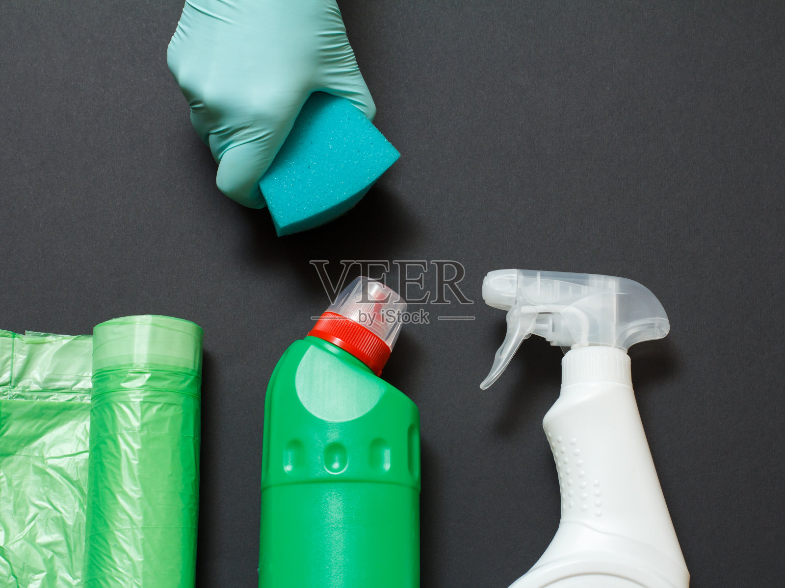 女人的手在一个手套与海绵和清洁设置在黑色背景。照片摄影图片