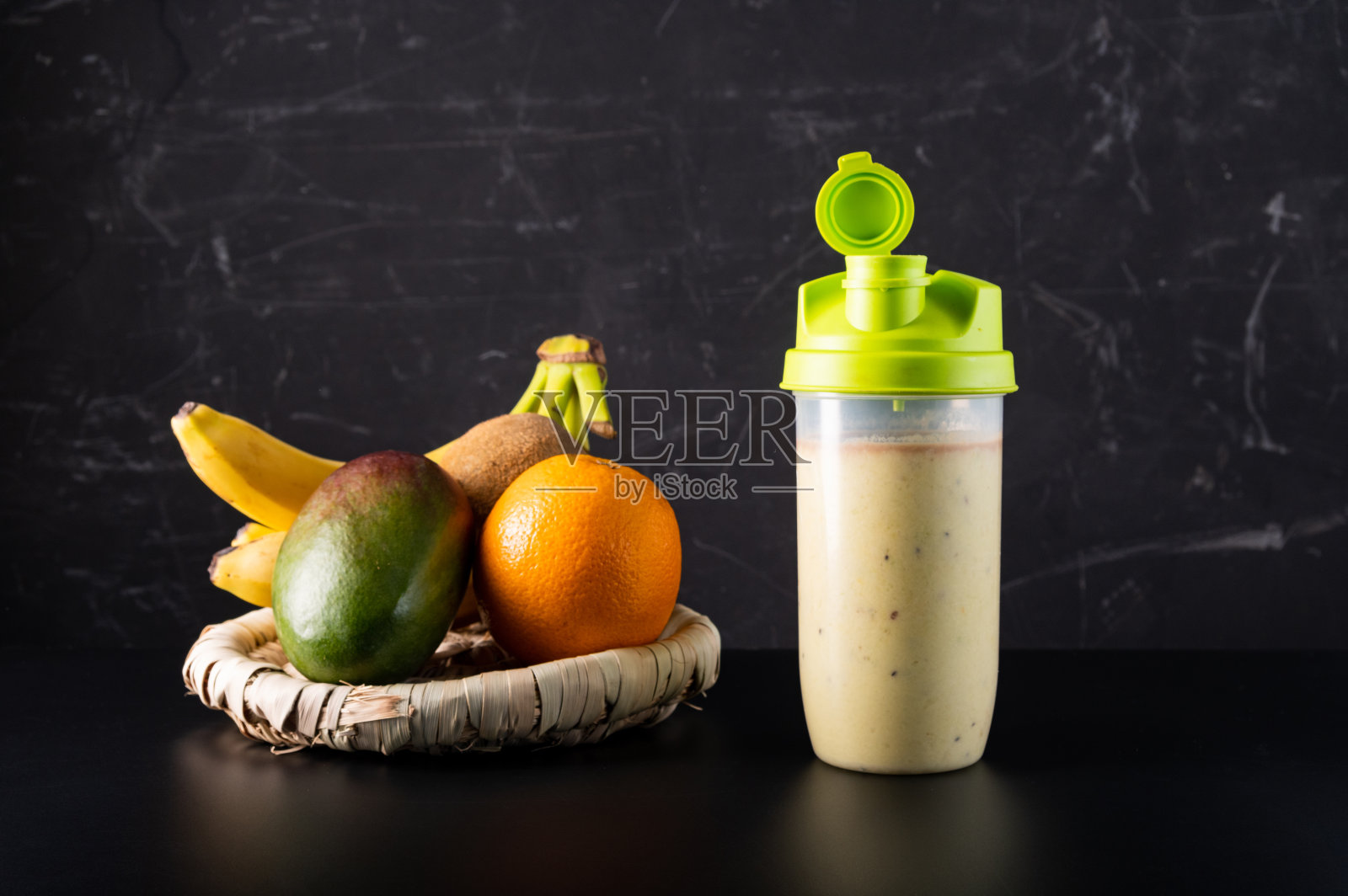 黑色背景上的牛奶水果鸡尾酒。鸡尾酒在摇酒器。照片摄影图片