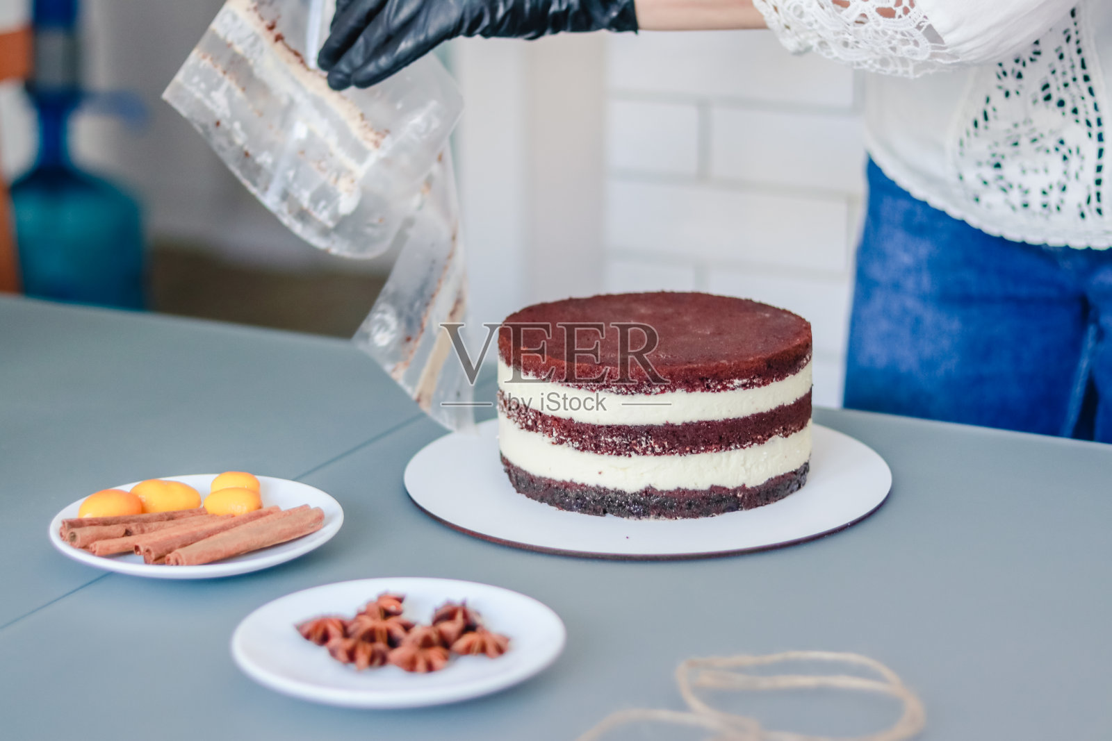 糕点师从裸露的蛋糕上取下边缘胶带照片摄影图片