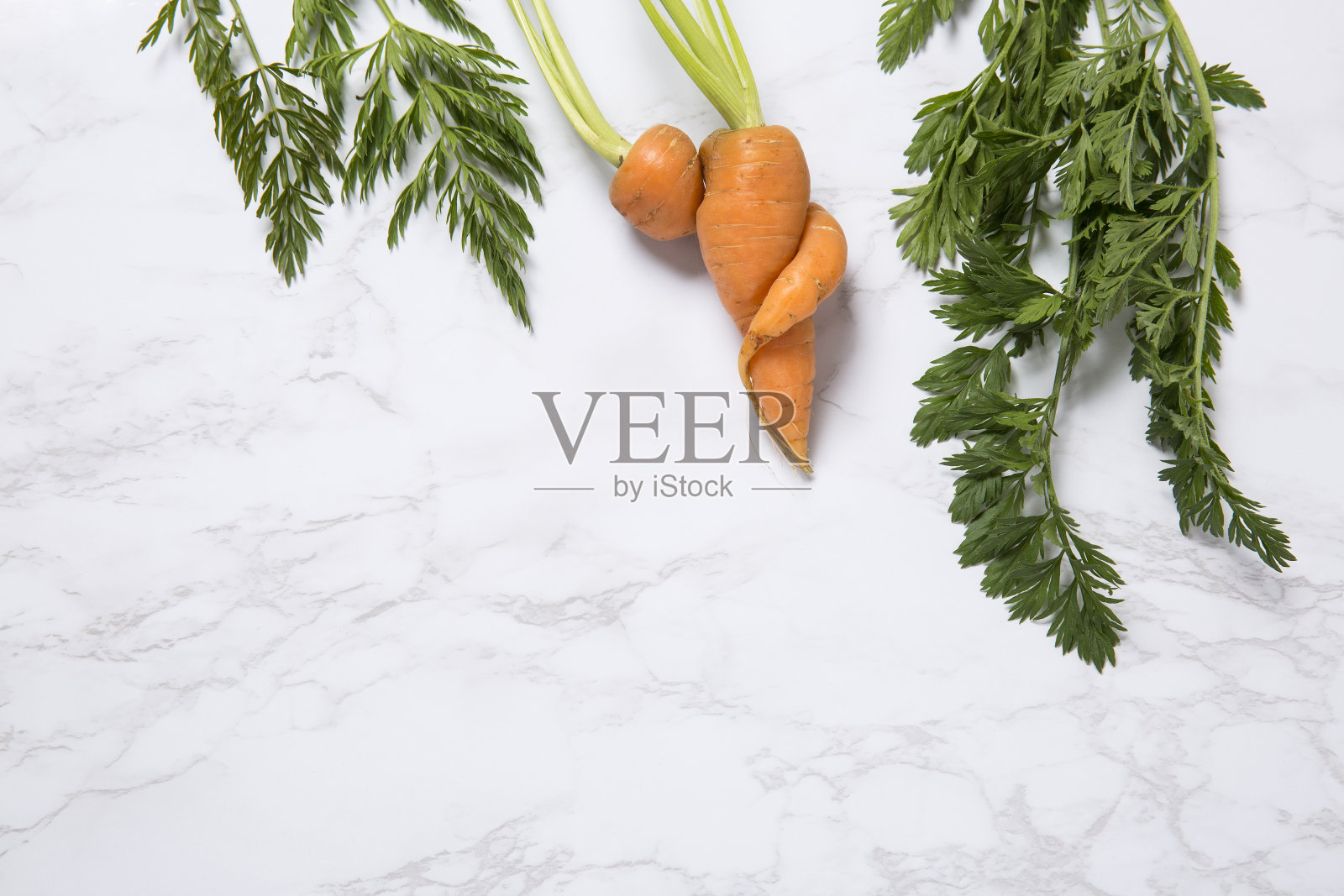 大理石背景上不完美的胡萝卜的局部视图照片摄影图片