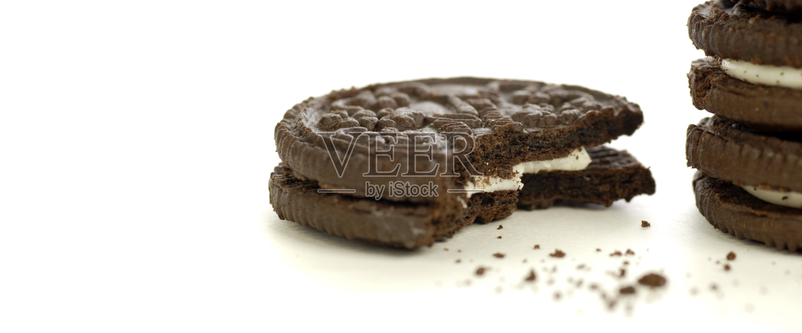 奶油夹心的巧克力曲奇，白色背景上的面包屑照片摄影图片