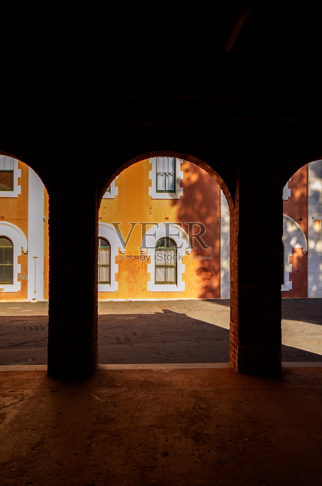 透过石拱，可以看到古老建筑的庭院。照片摄影图片