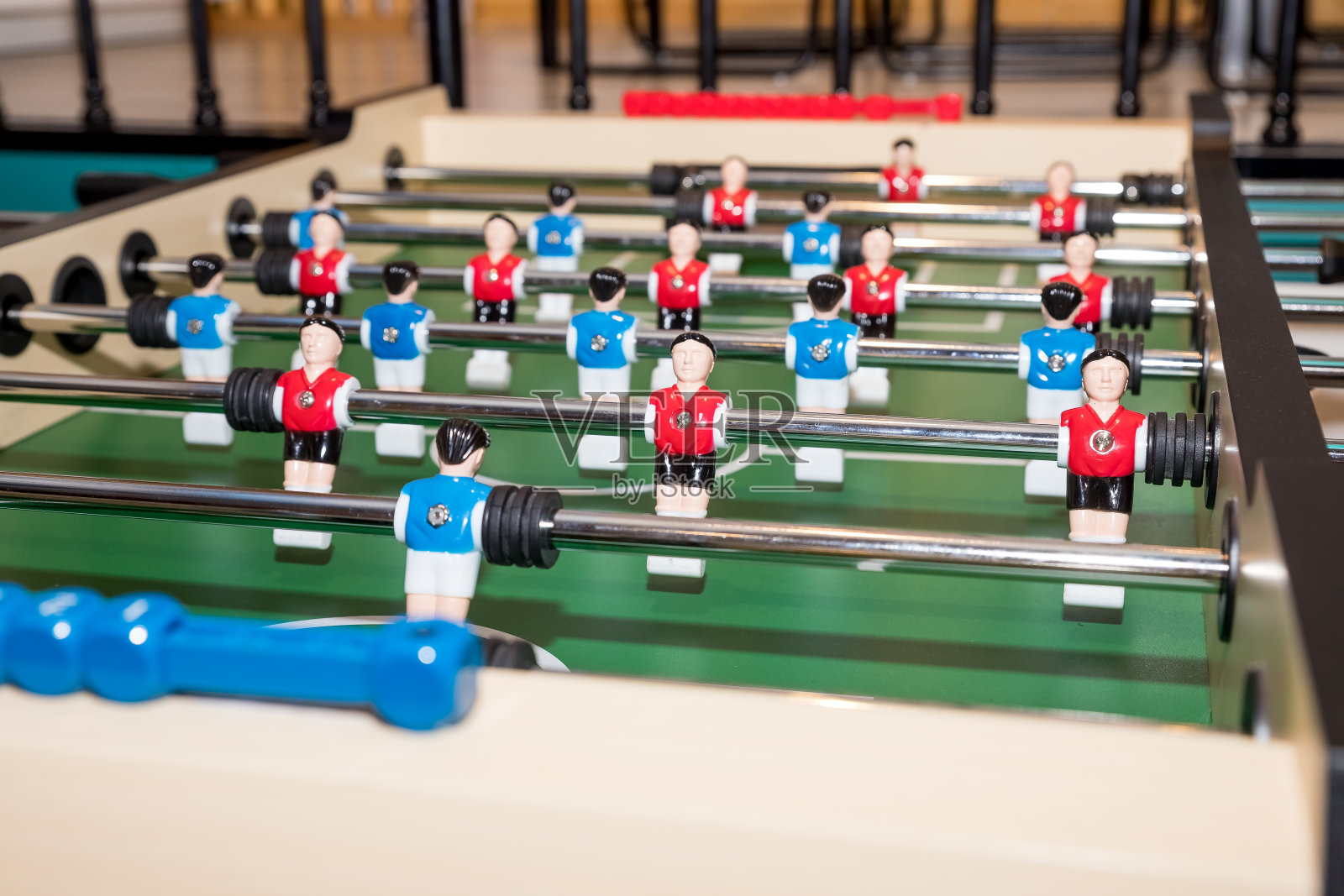 足球比赛，足球桌与红色和蓝色的球员。娃娃的复古游戏。足球运动员的微型踢球桌游戏照片摄影图片