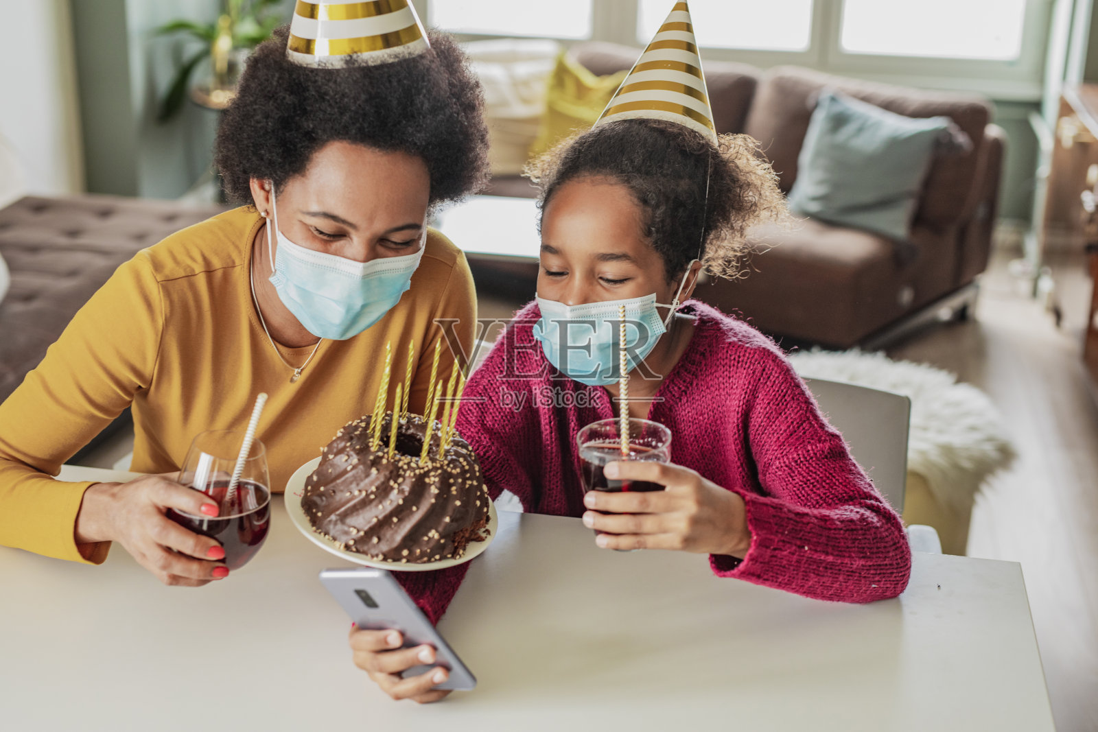 母亲和女儿通过手机在家在线庆祝生日照片摄影图片