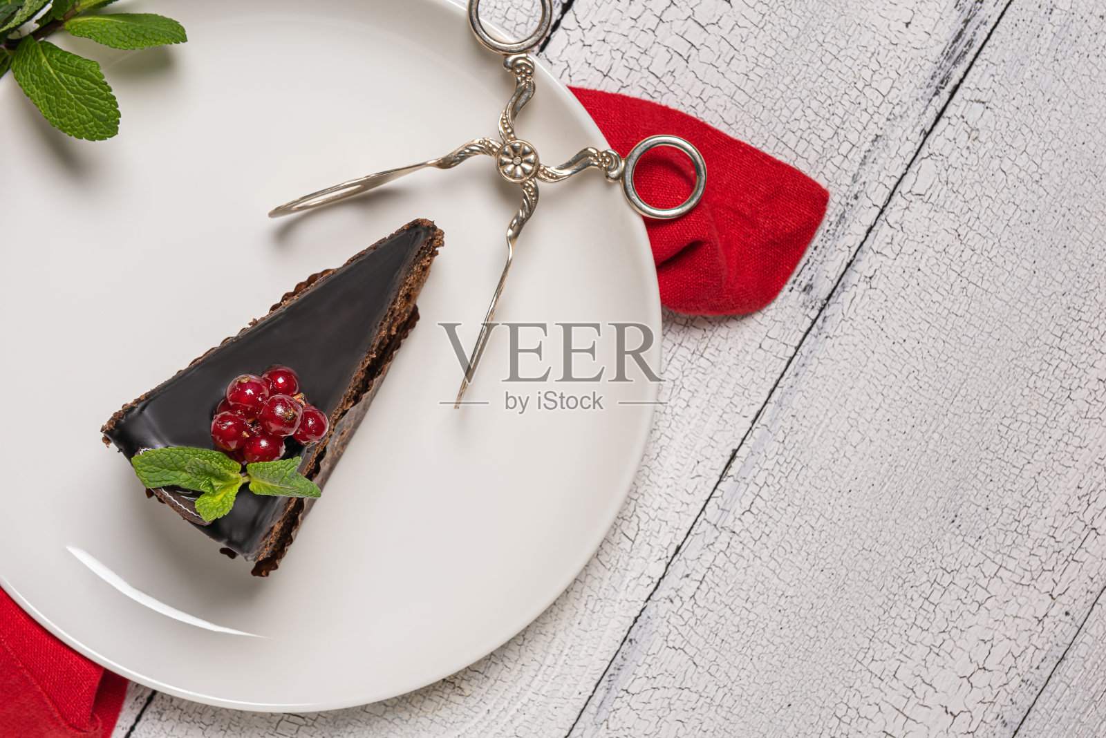 一块巧克力莫扎特蛋糕和钳子盘在木桌和复制空间照片摄影图片