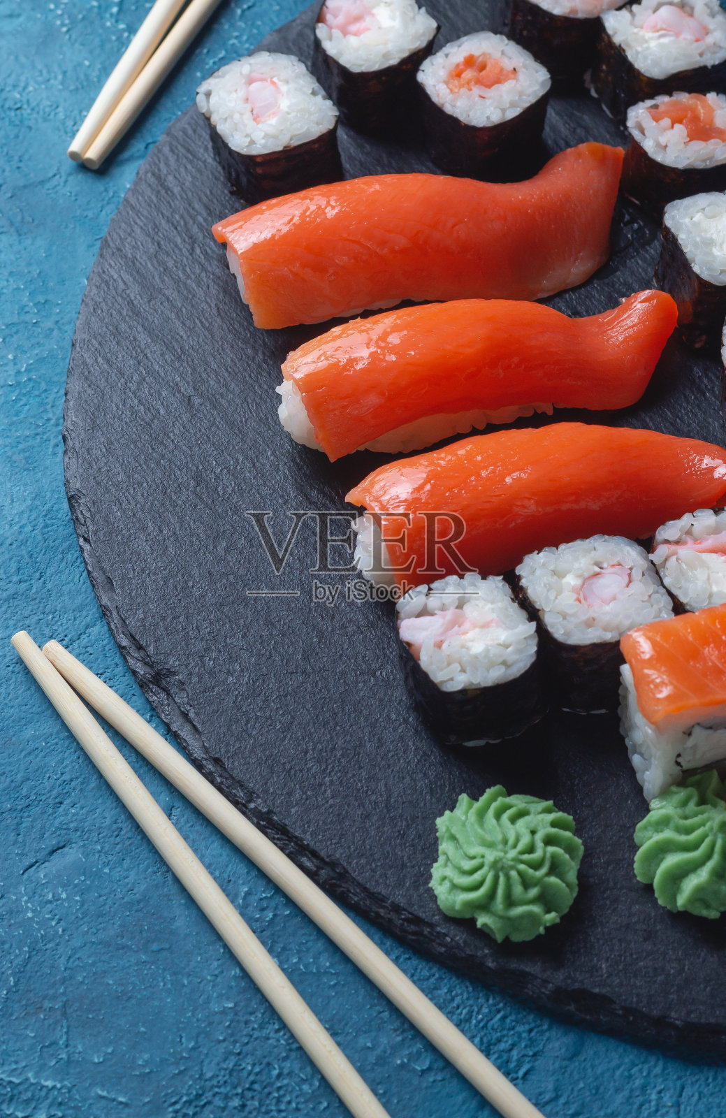 三文鱼蓝色背景的寿司卷。俯视图的传统日本料理。现代设计的亚洲餐厅菜单照片摄影图片