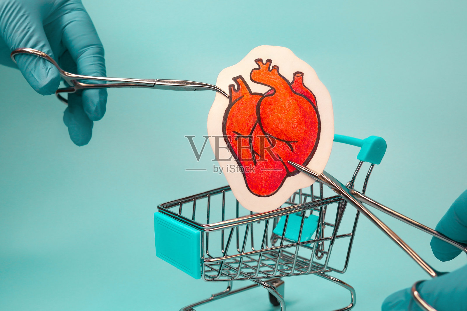 医生的手降低了心进入购物车。照片摄影图片
