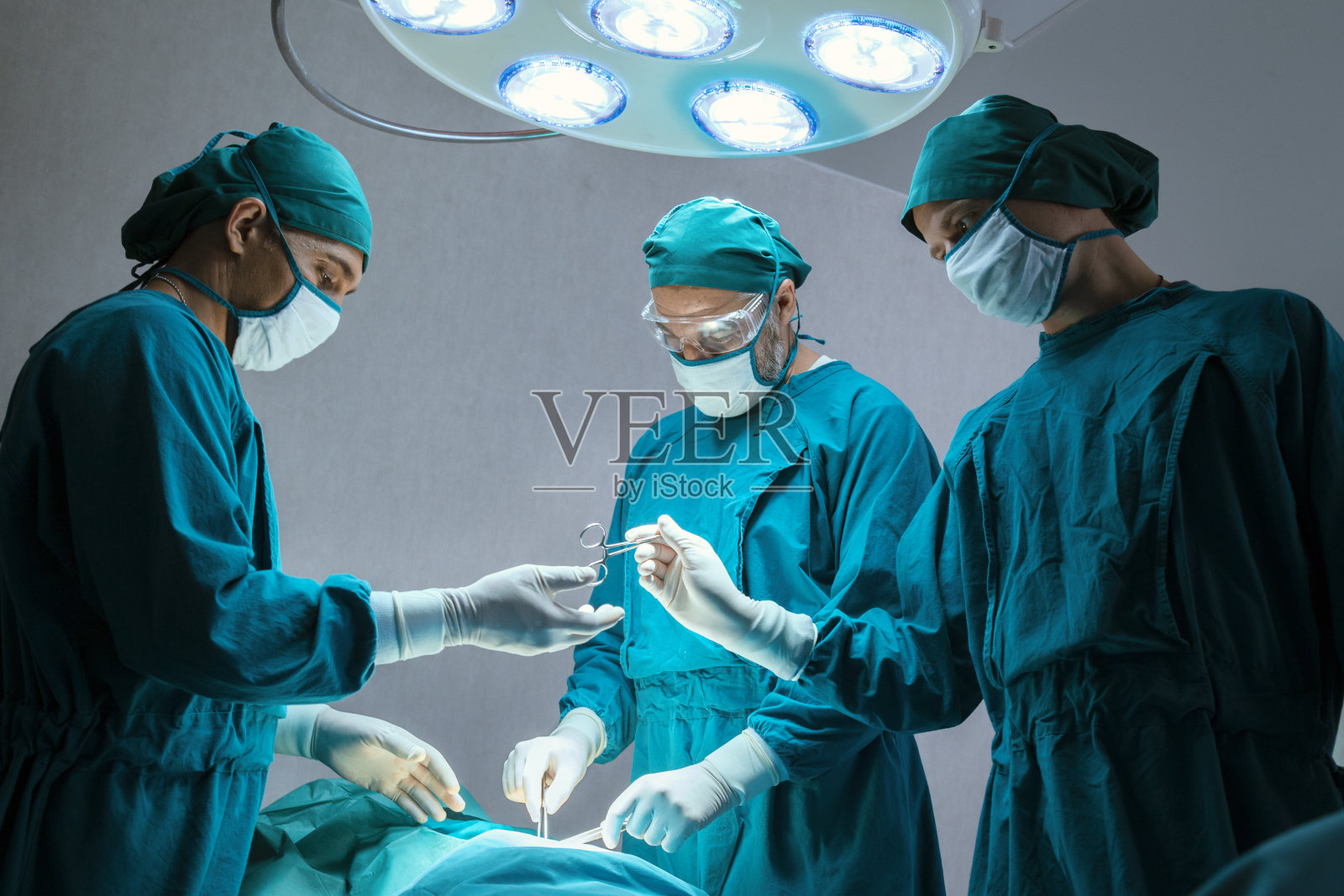 专业外科医生团队集中在医院的手术室里给病人做手术。医疗保健和医疗理念。“n照片摄影图片
